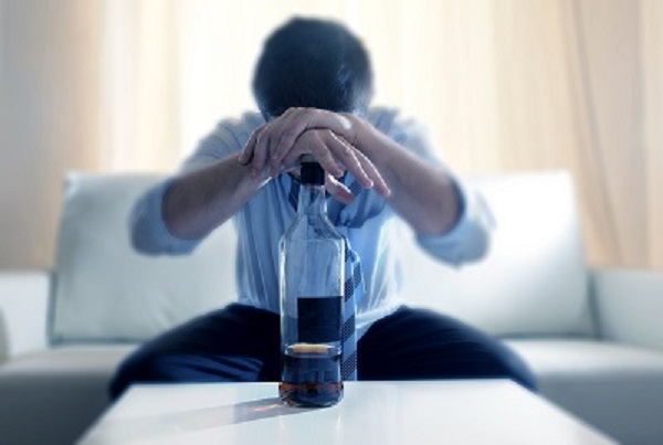 man leaning over liquor bottle