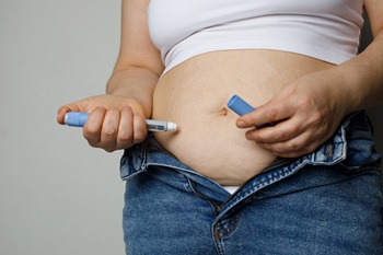 Obese woman injecting weight-loss drug